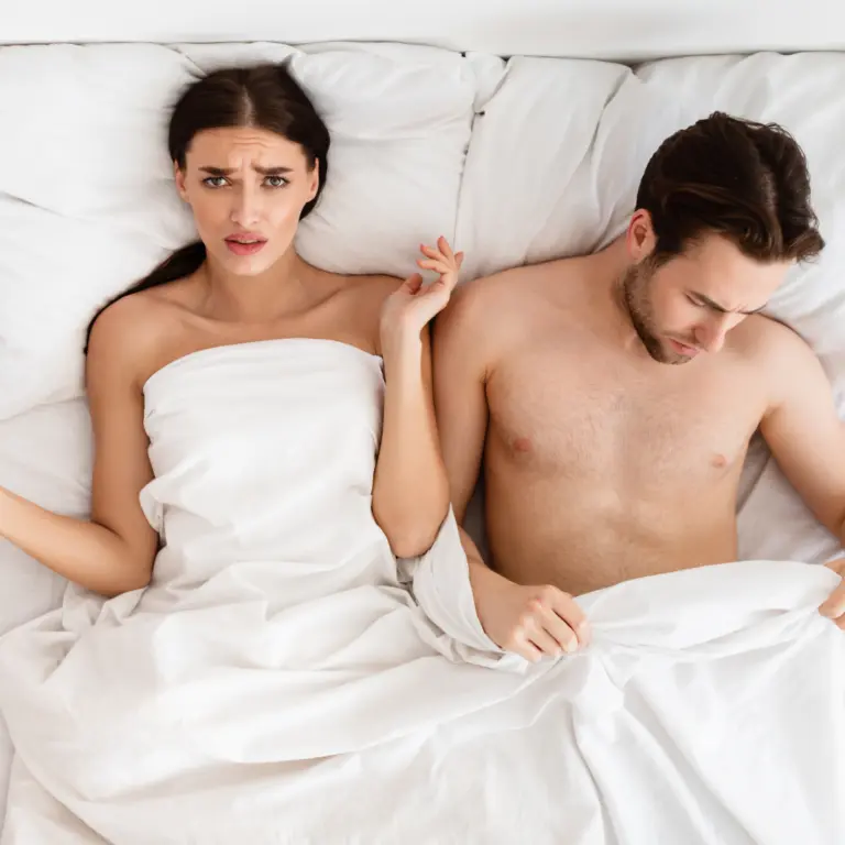 Couple lying in bed, turned away from each other
