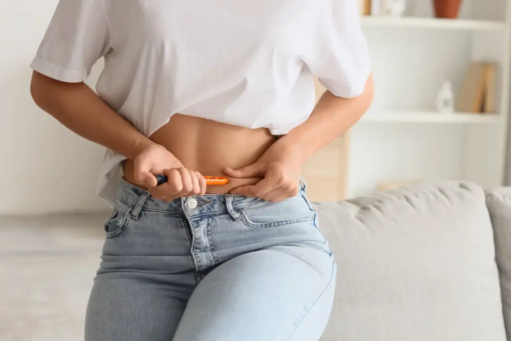 Woman giving herself an injection in the stomach