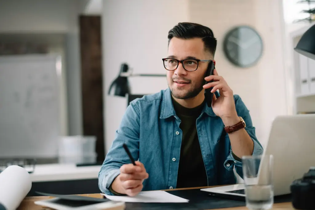 Smiling man on the phone at his desk