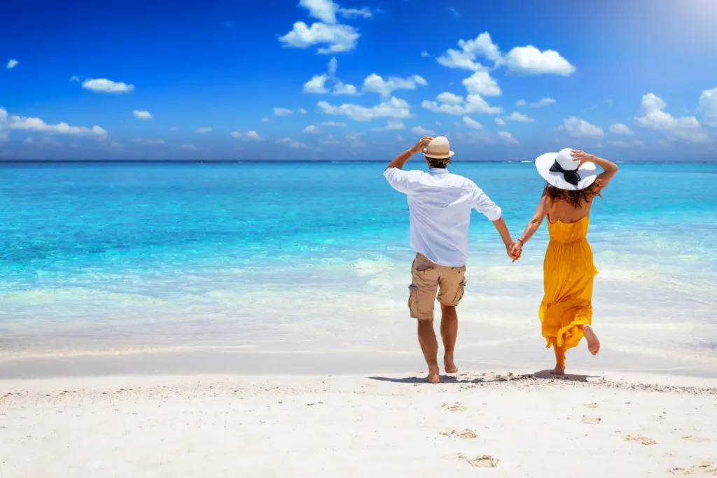 Couple walking hand in hand on a tropical beach