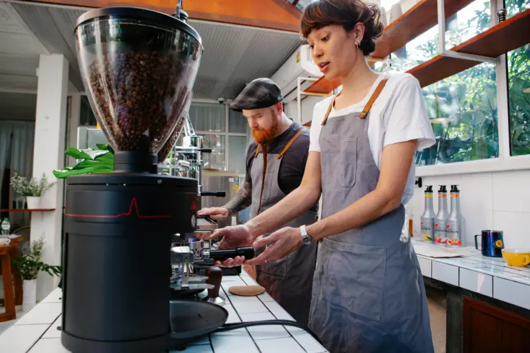 Two employees working behind a cafe counter