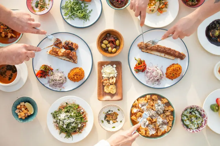 Overhead view of hands reaching for healthy dishes on a table