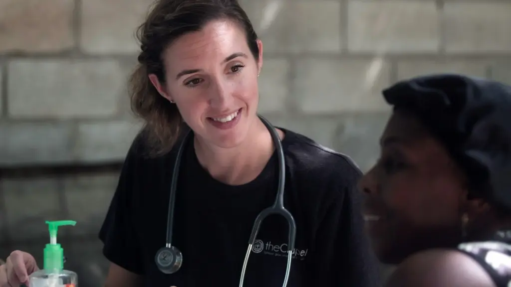 Smiling clinician with a stethoscope talking with a patient