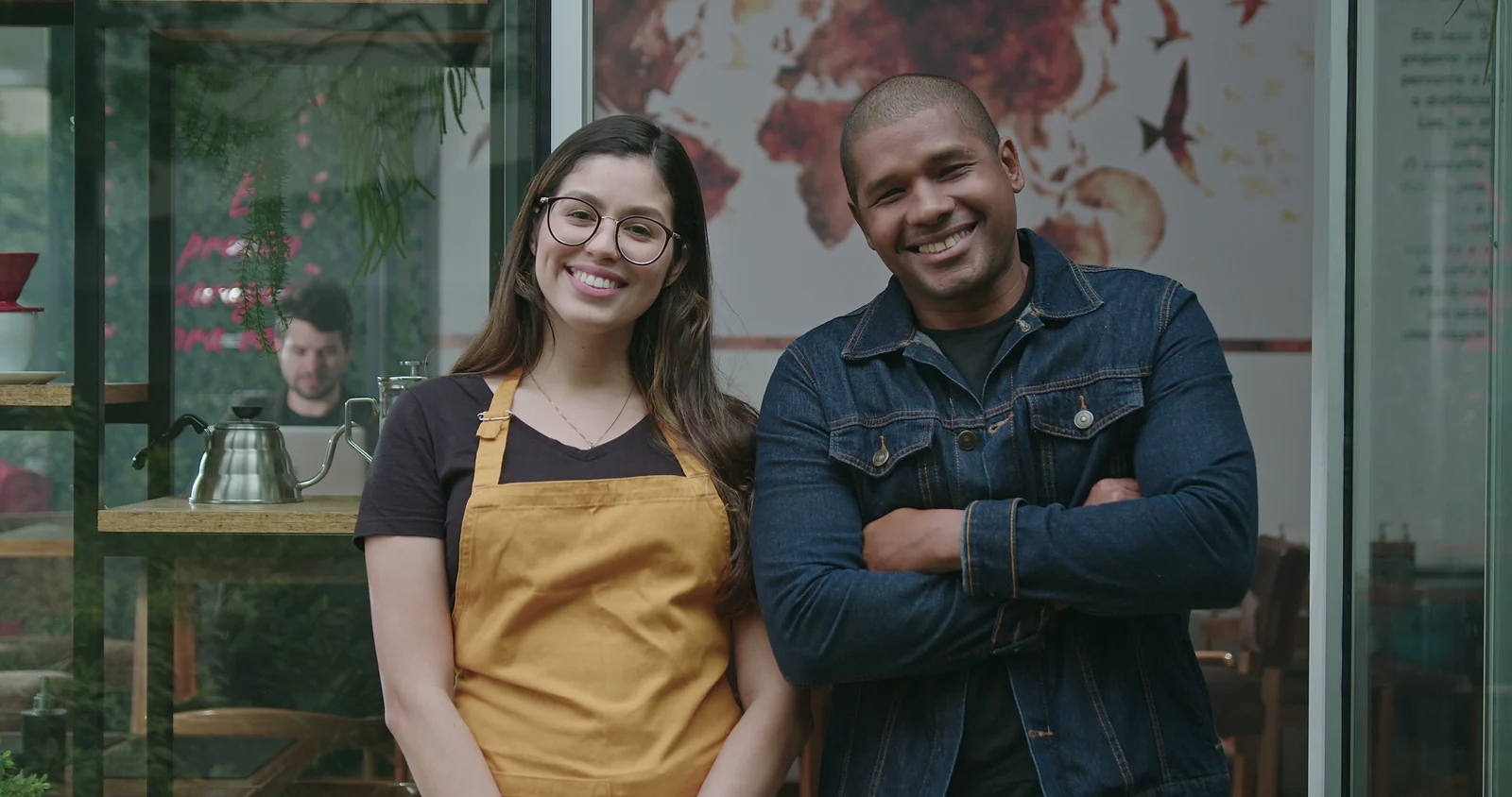 Two smiling small business owners in aprons