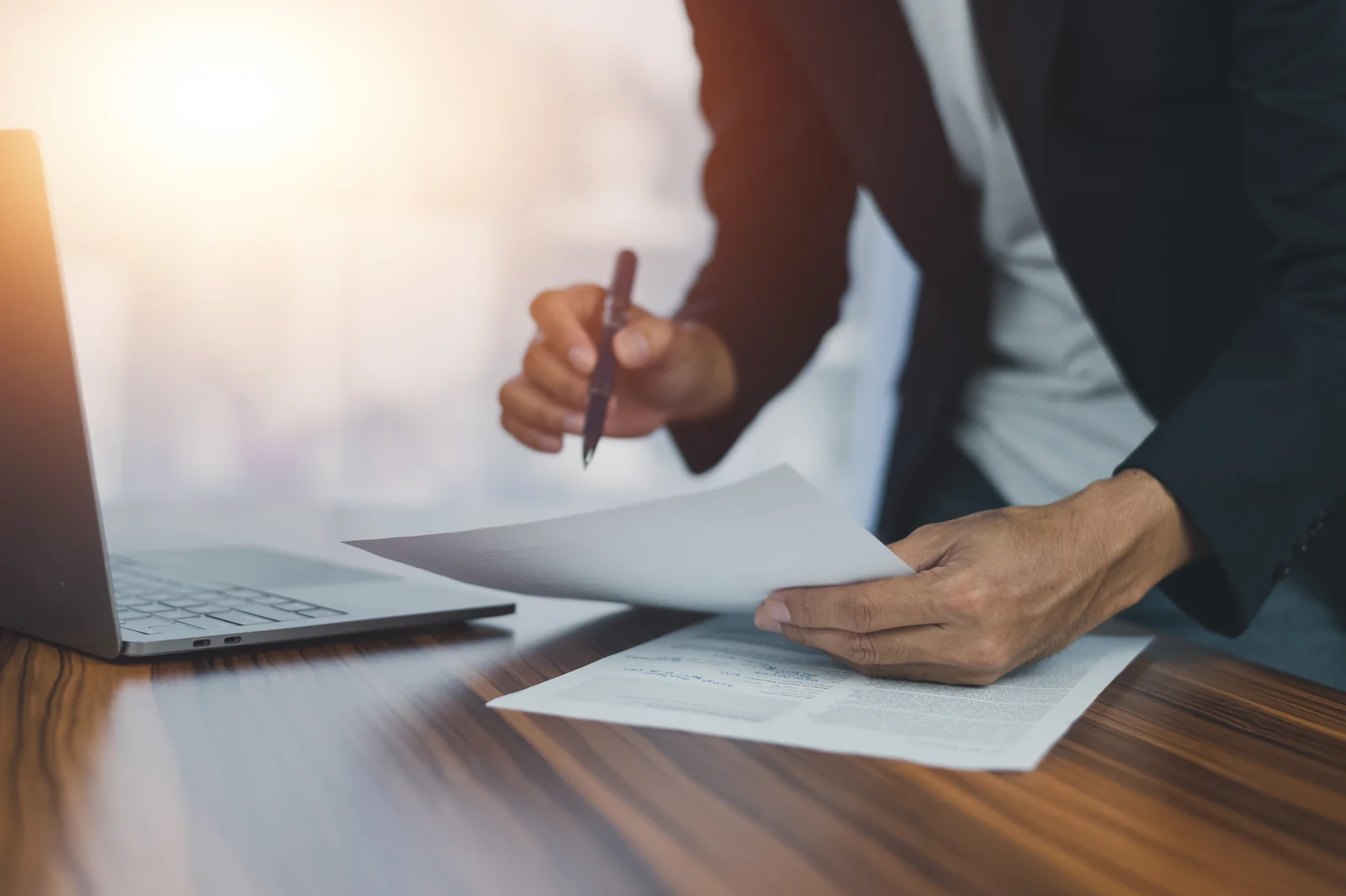 Person signing a document at a desk